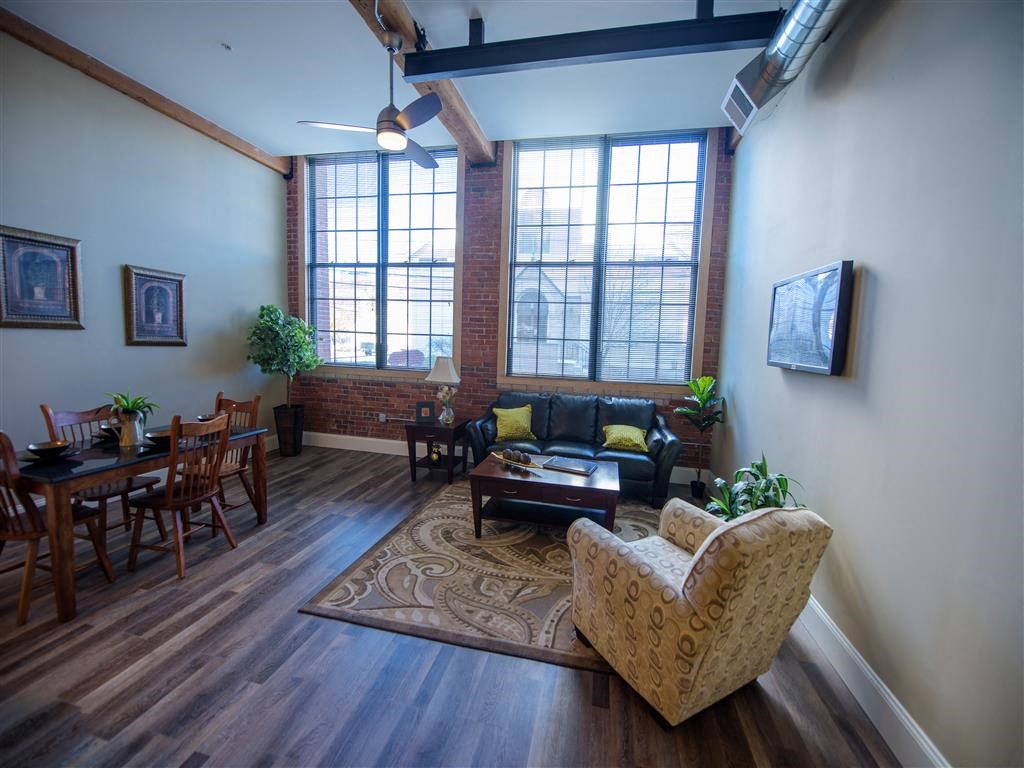A living room with a couch, chairs, and a rug.