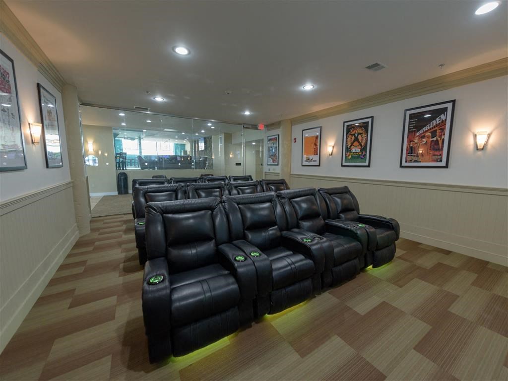 A row of black leather recliner chairs are lined up in a room.