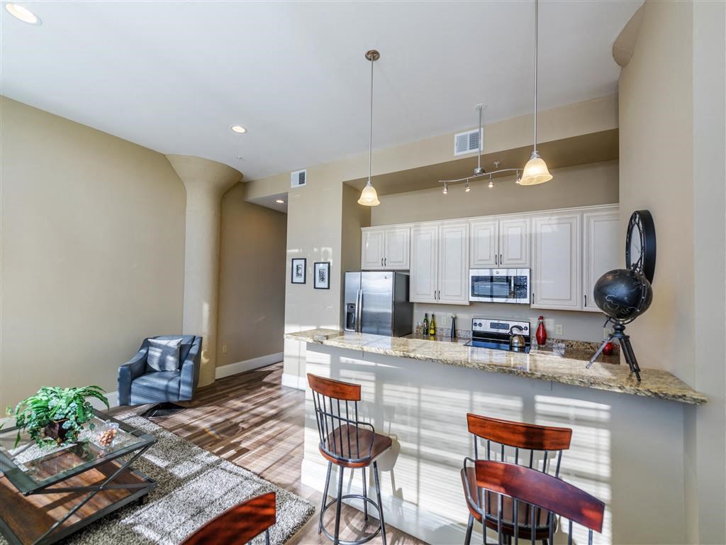 A kitchen with a bar area and a dining table with chairs.