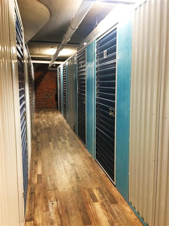 A long hallway with a wooden floor and metal walls.