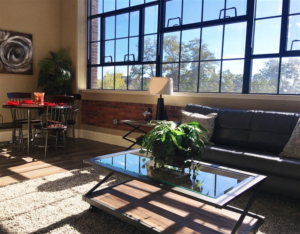 A living room with a glass coffee table and a couch.