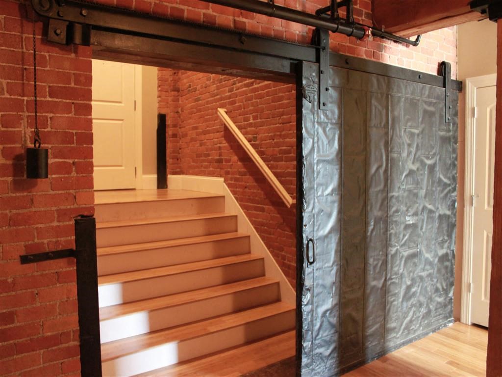A set of stairs with a brick wall on one side and a metal gate on the other.