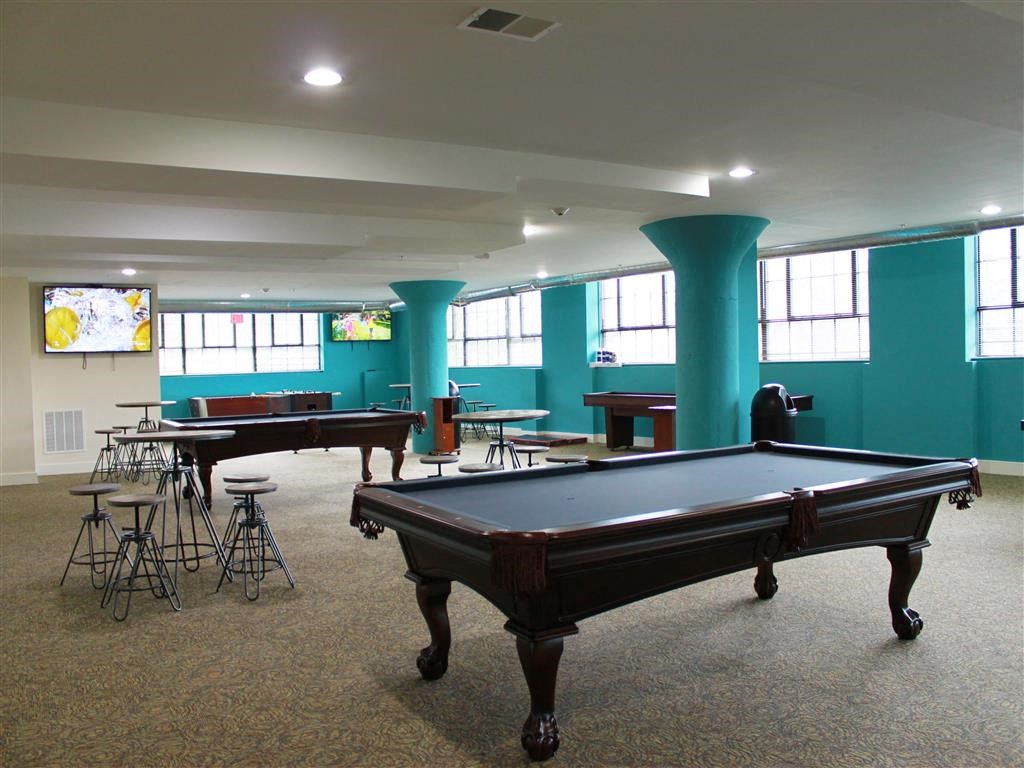 a games room with a pool table and tables
