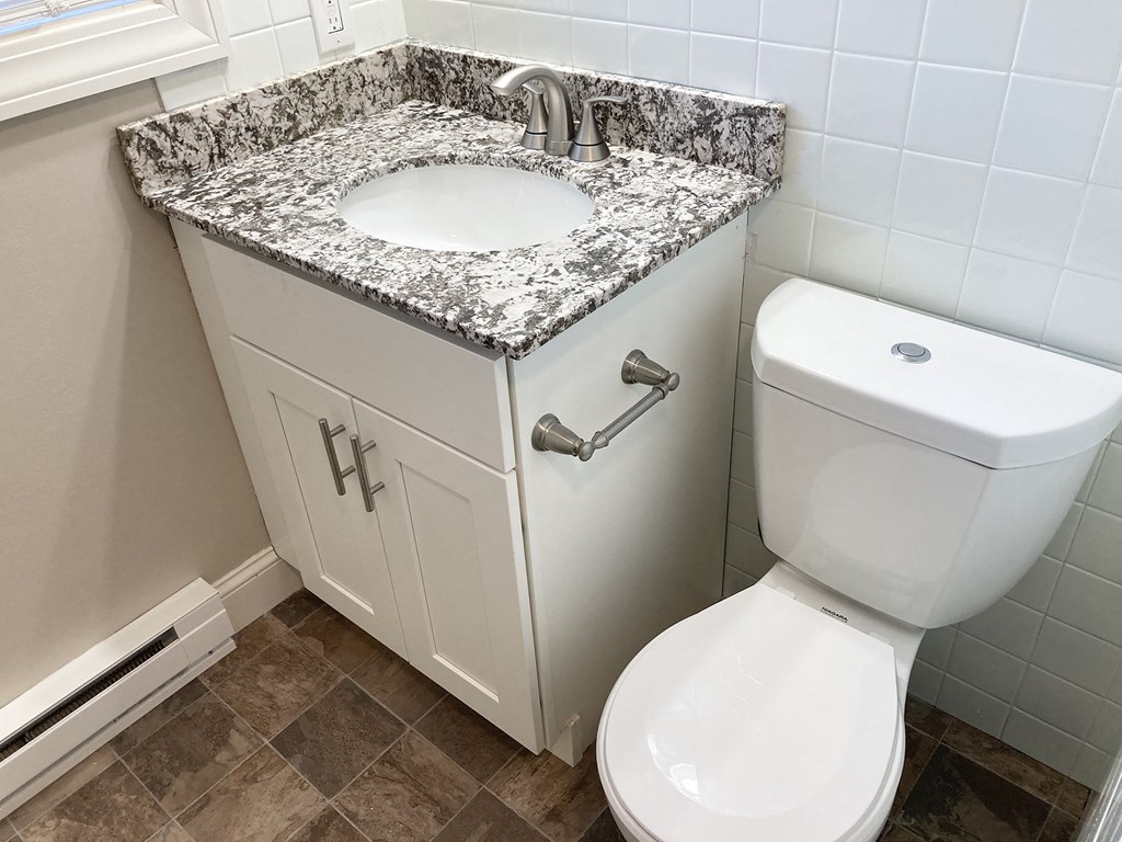 a small bathroom with a sink and toilet and a toilet paper dispenser