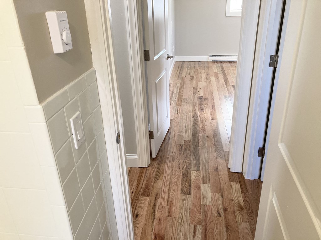 a home with wood flooring in a hallway
