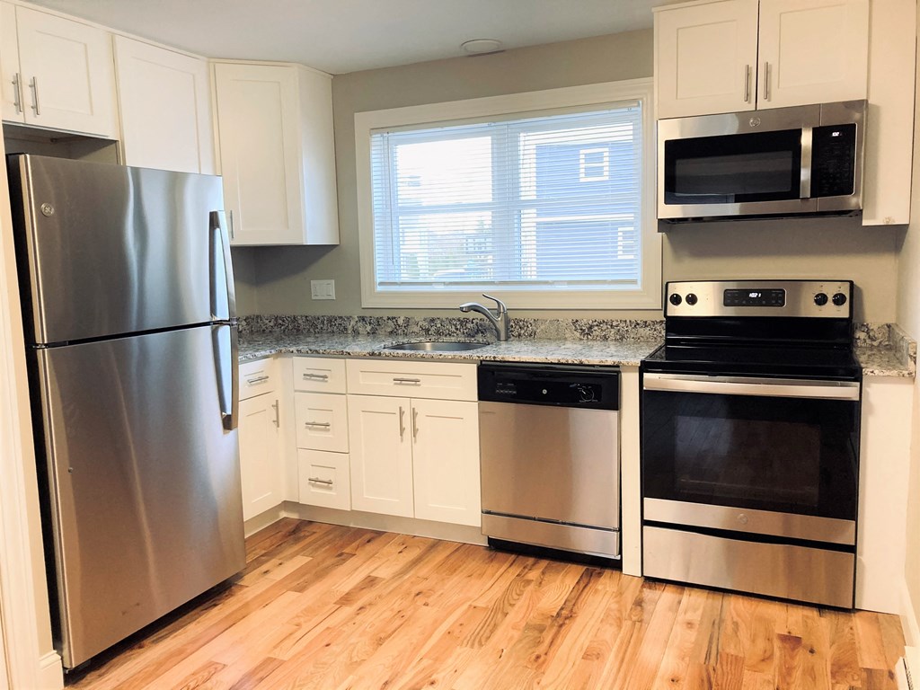 a kitchen with stainless steel appliances and white cabinets