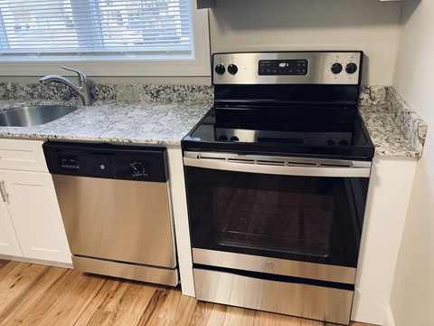 a kitchen with a stove and a sink and a window