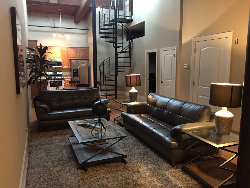 a living room with leather couches and a glass table