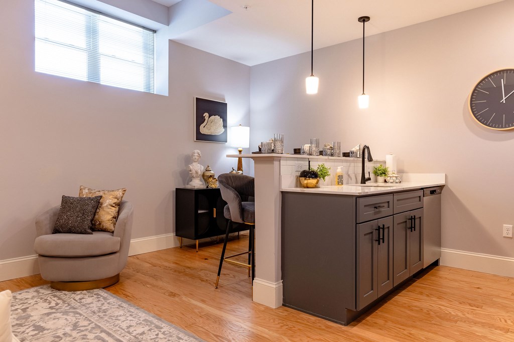 A kitchen with a grey chair and a grey cabinet.