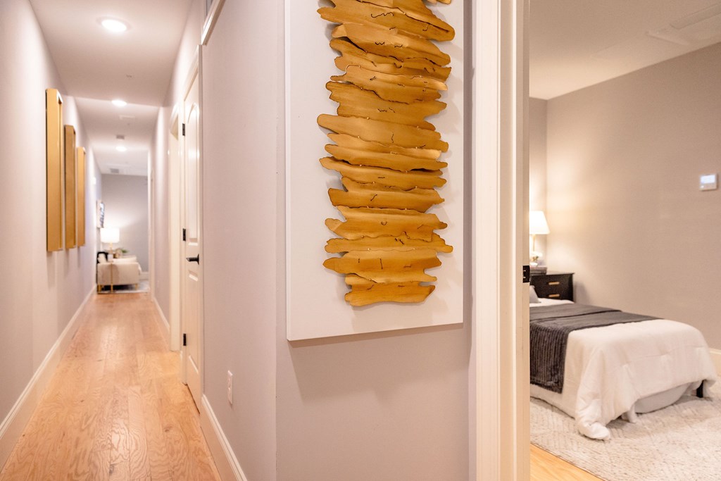 A long hallway with a large yellow sculpture on the wall.