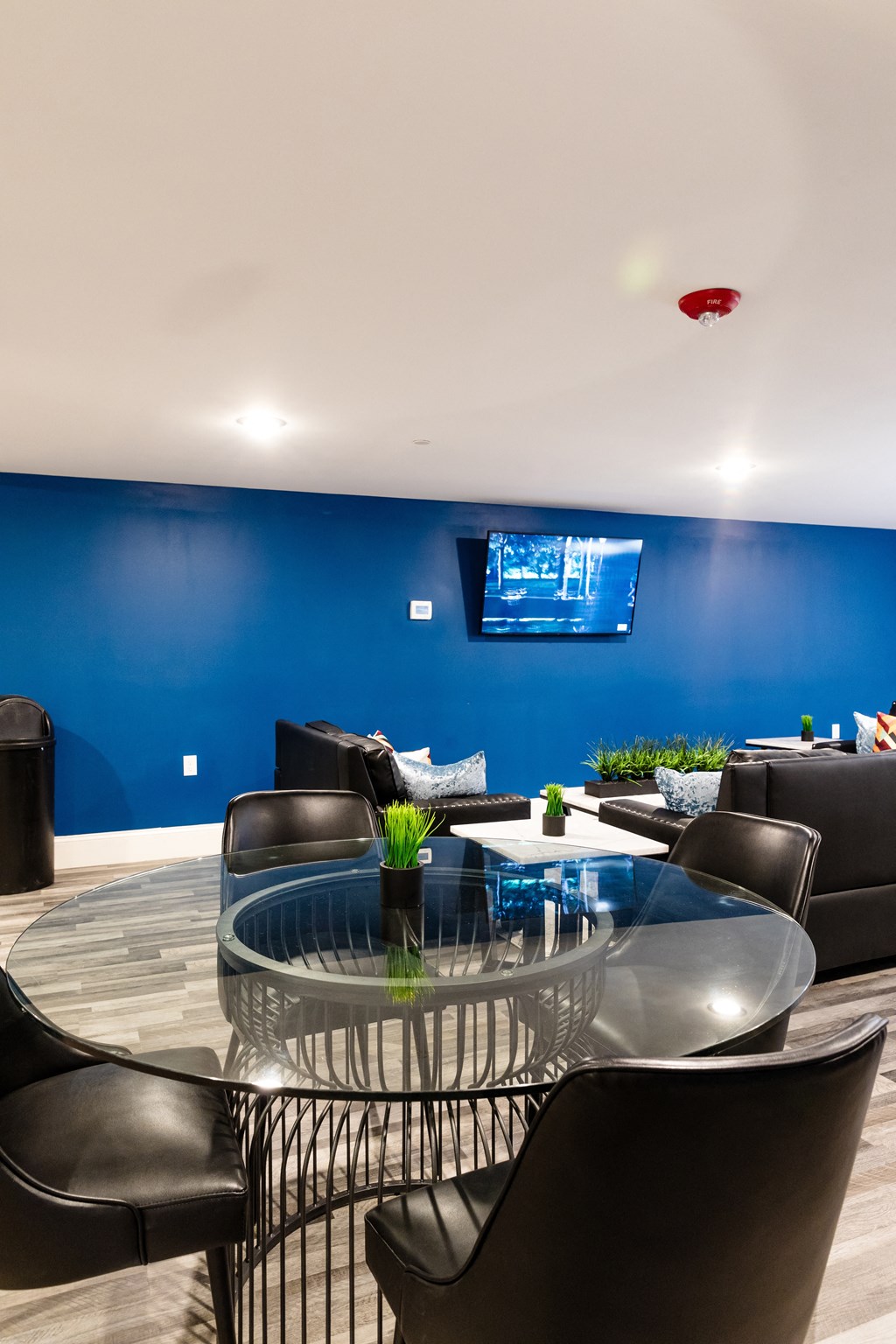 a living room with a blue wall and a glass table and chairs