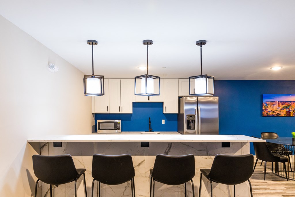 a kitchen with a blue wall and a counter with chairs