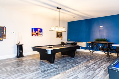 a game room with a blue accent wall and a pool table