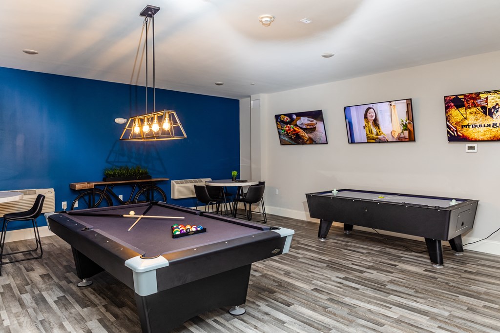 a game room with two pool tables and a ping pong table