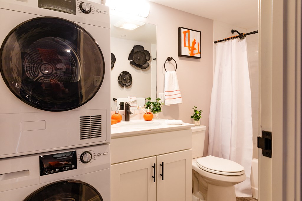 a bathroom with a toilet and a washer and dryer in it