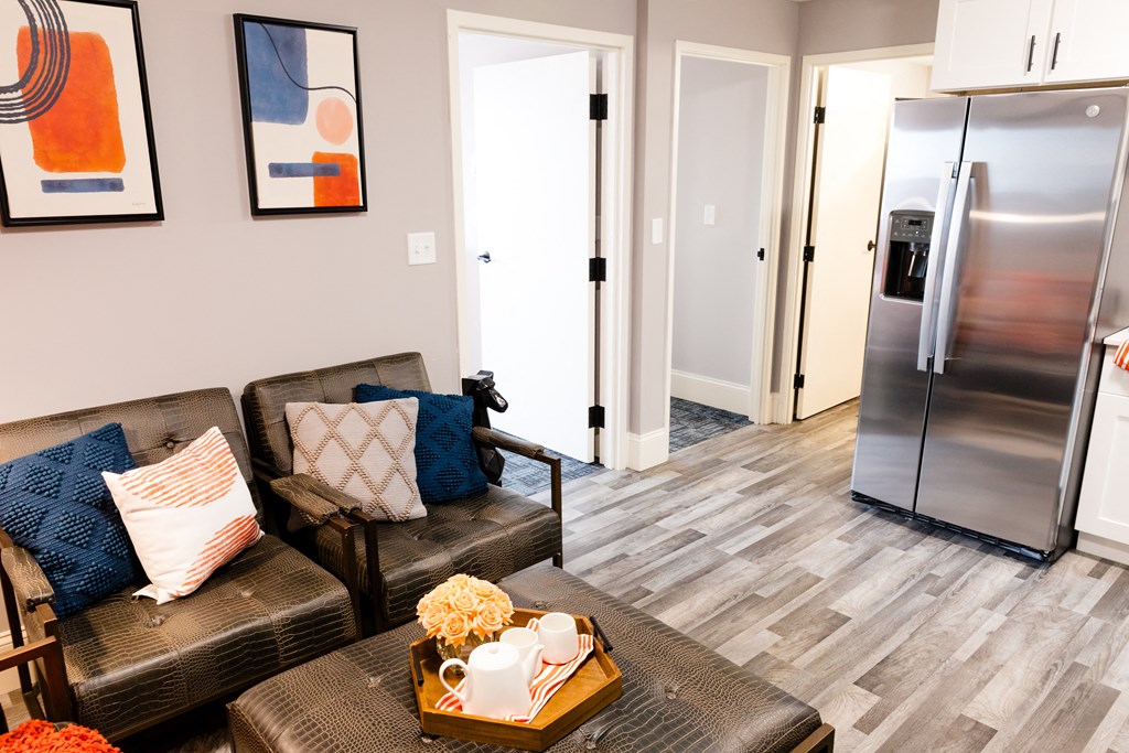 a living room with a couch and a coffee table and a refrigerator