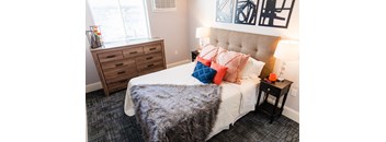 a bedroom with a bed with a blanket and pillows on it