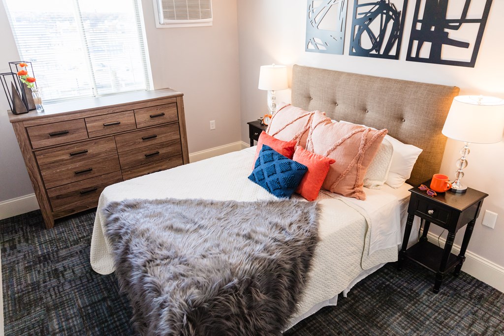 a bedroom with a bed with a blanket and pillows on it