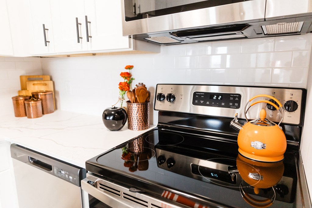 a kitchen with an orange kettle on the stove