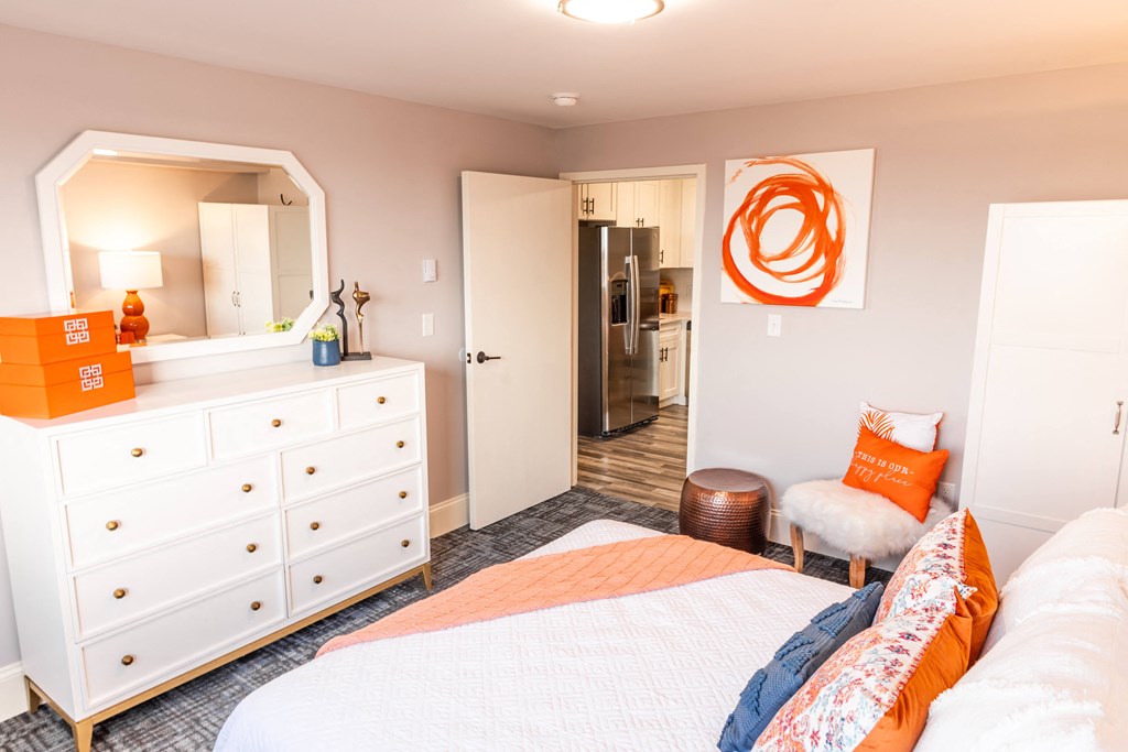 a bedroom with a bed and a dresser and a bathroom