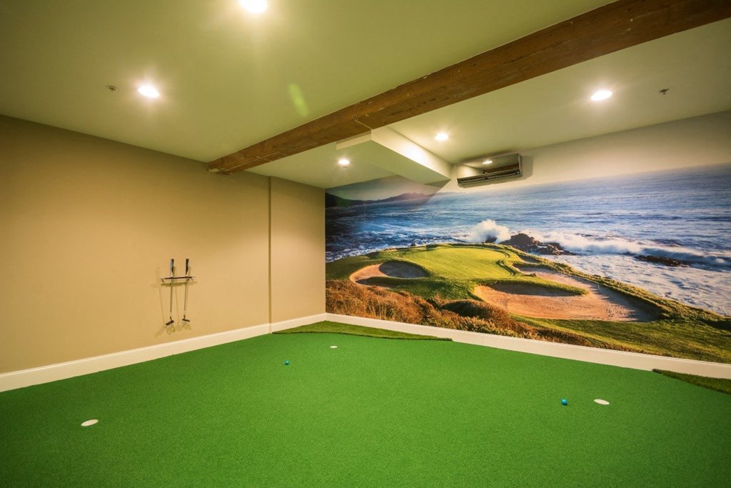 a game room with a simulator and a painting of the ocean on the wall