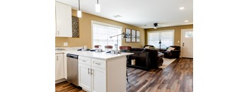A kitchen with white cabinets and a black countertop.