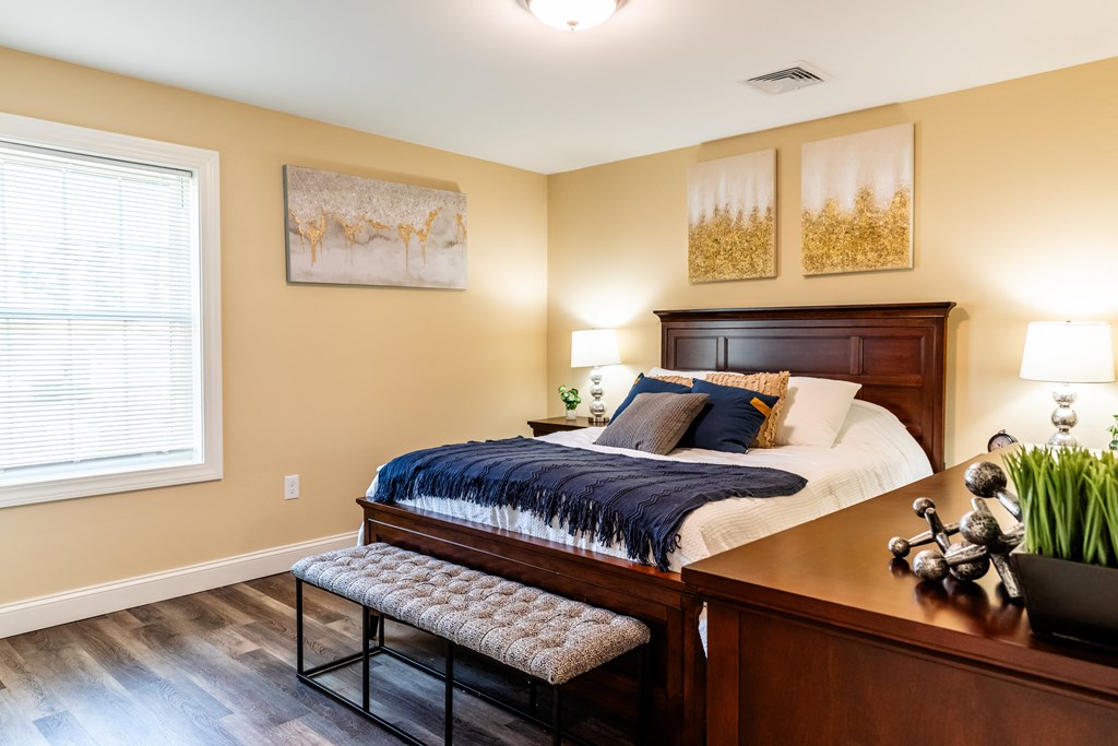 a bedroom with a bed and a desk and a window