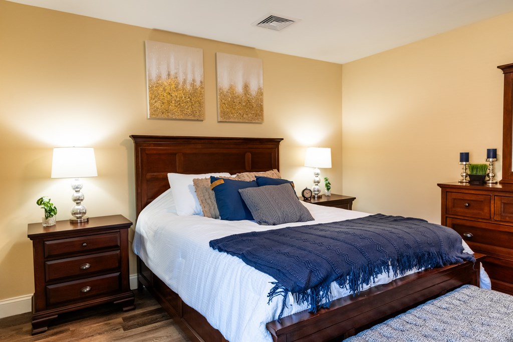 a bedroom with a bed with a blue blanket and pillows