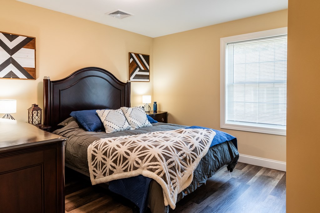 a bedroom with a bed and a dresser and a window