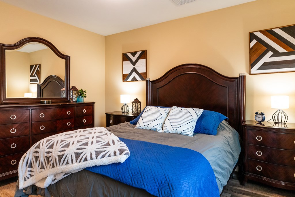 a bedroom with a bed and two dressers