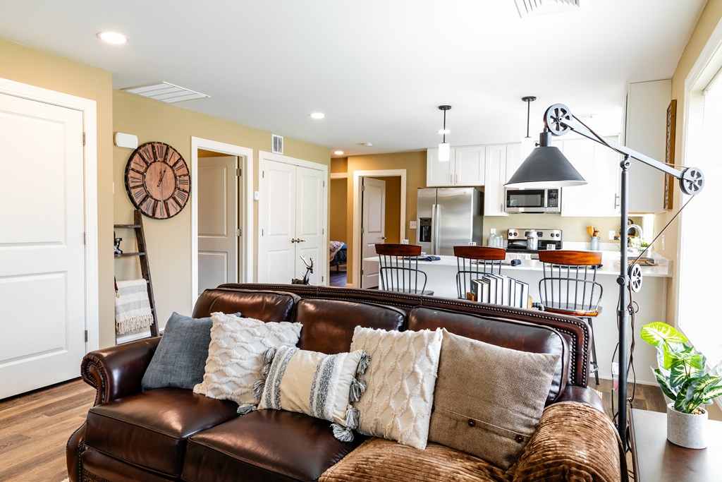 a living room with a leather couch and a kitchen