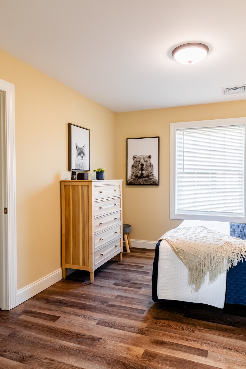 a bedroom with a bed and a dresser and a window