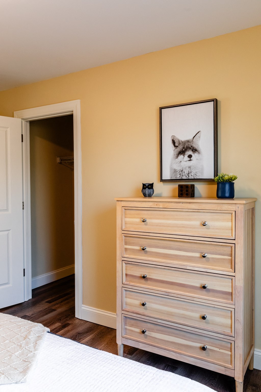 a bedroom with a dresser and a picture of a cat on it