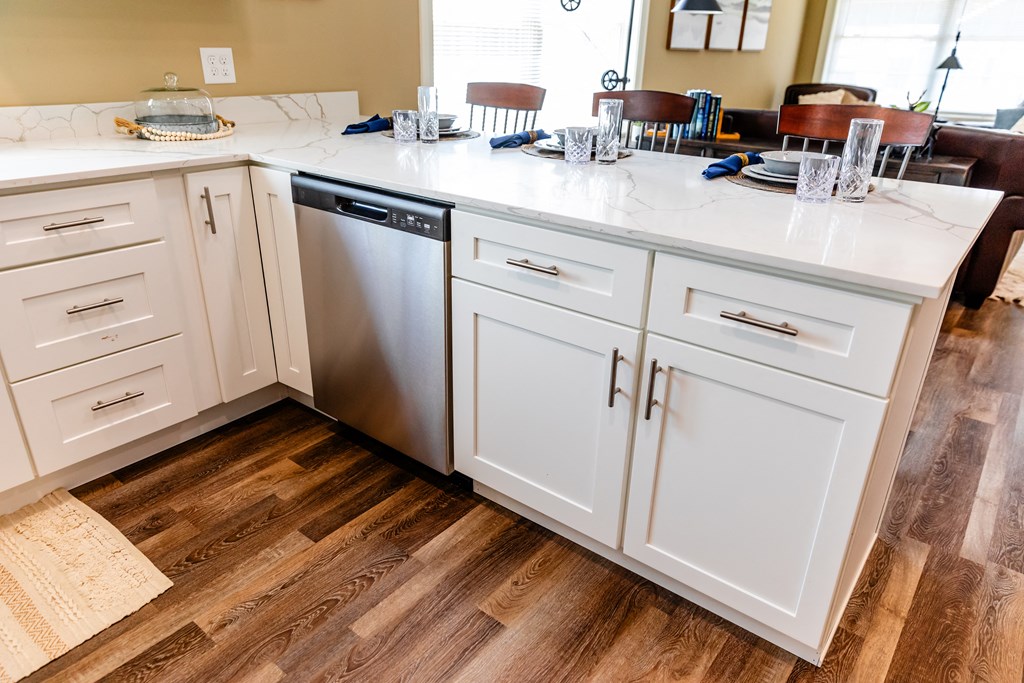 a kitchen with white cabinets and a stainless steel dishwasher