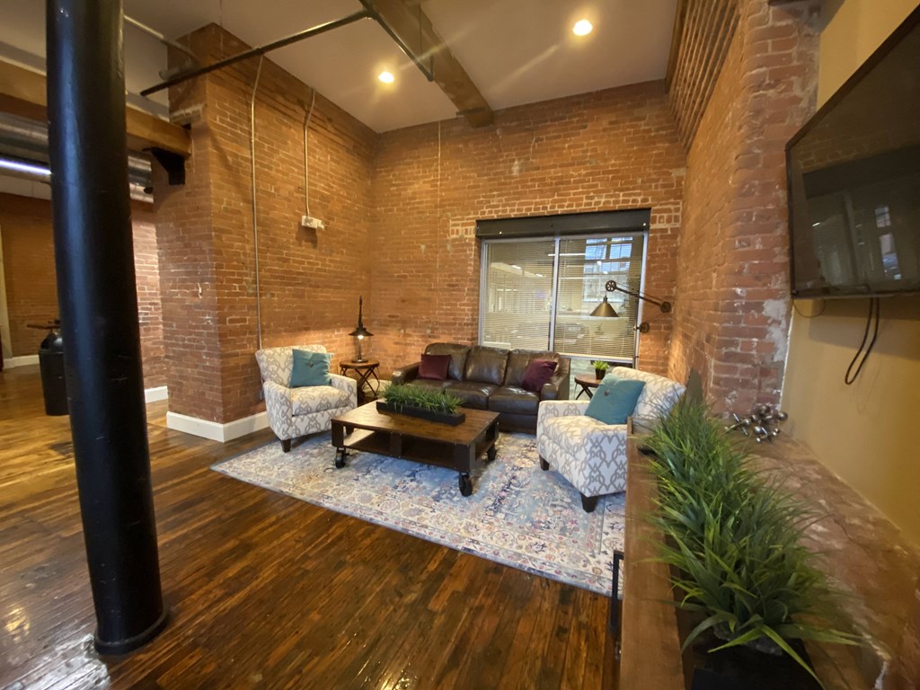 a living room with a brick wall and a tv