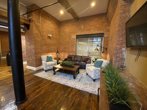a living room with a brick wall and a tv