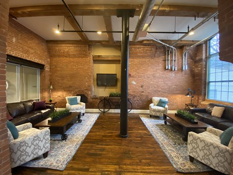 a large living room with a brick wall and a television