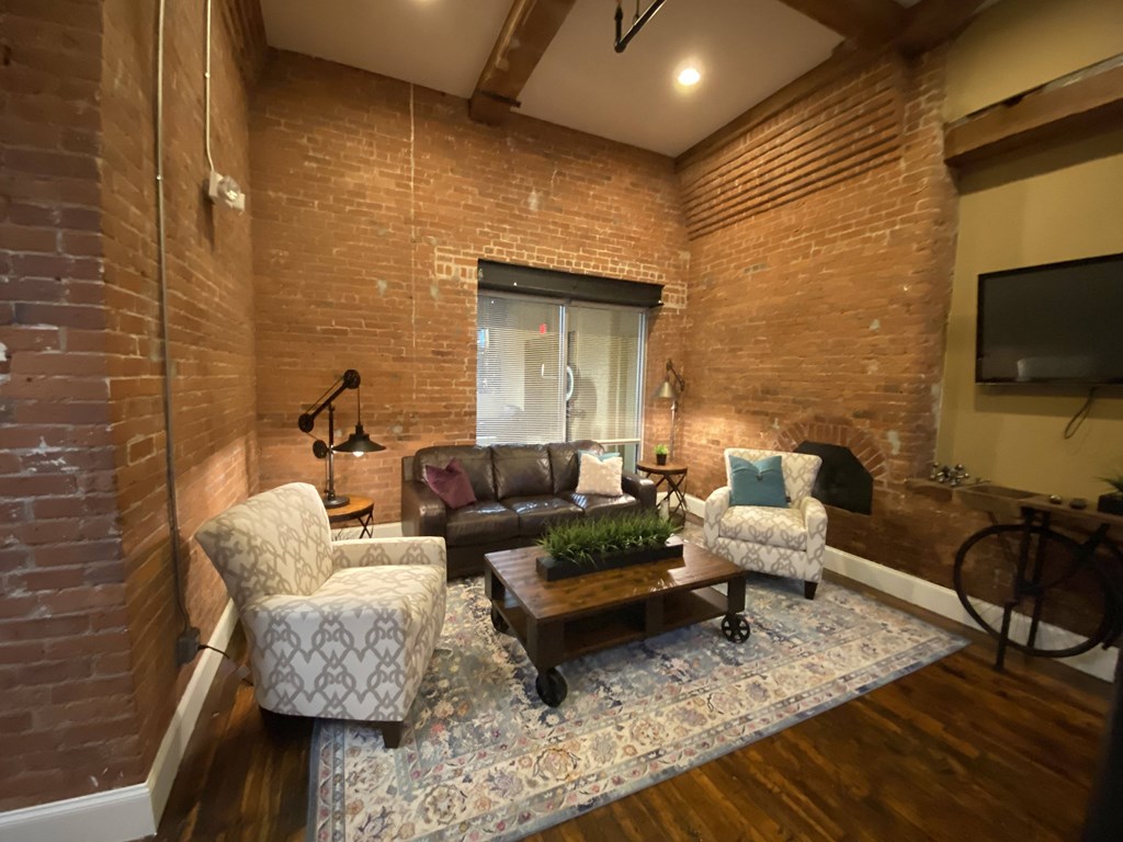 a living room with a brick wall and a couch and a coffee table