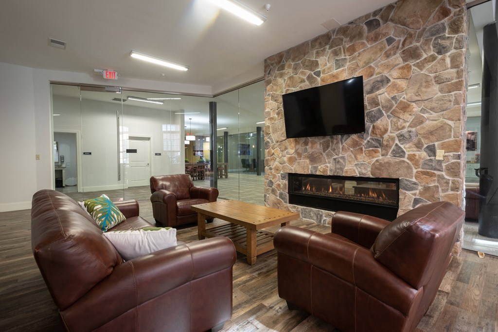 a living room with leather furniture and a stone fireplace