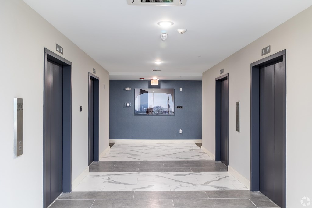 A hallway with two doors on either side and a window in the middle.