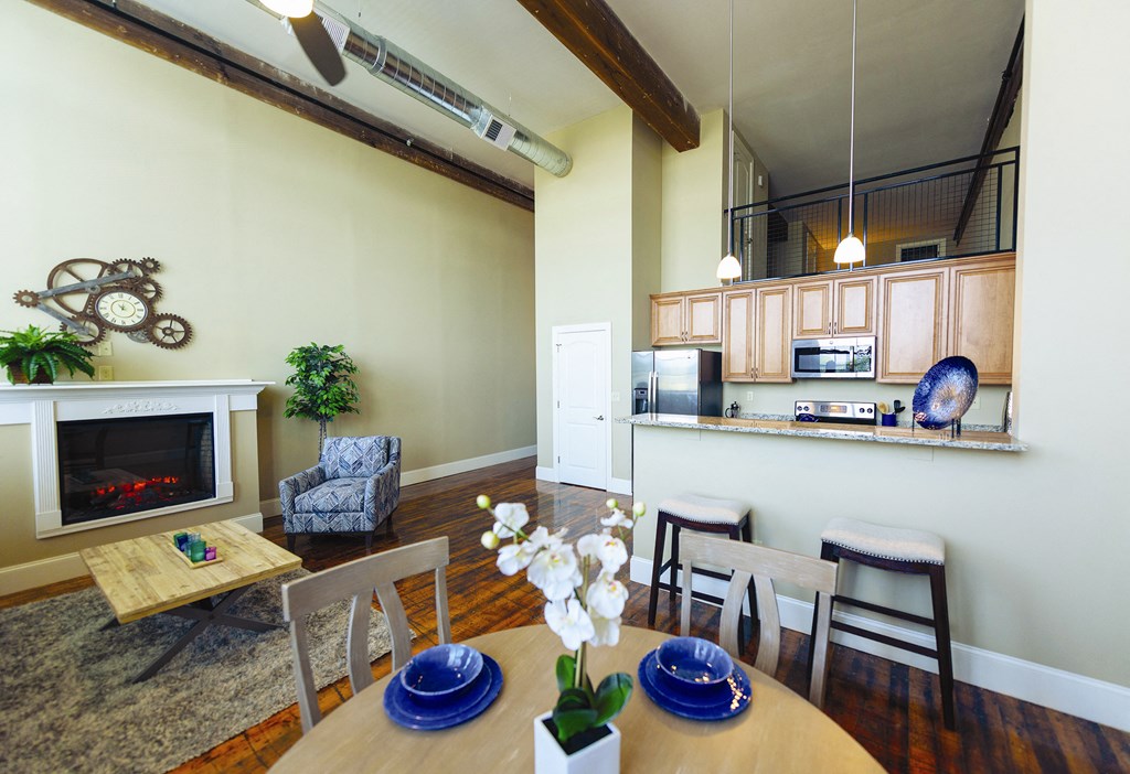 a living room with a dining room table and a fireplace