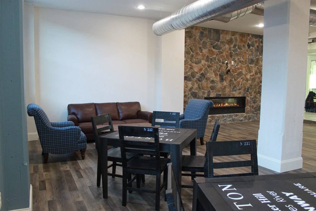 a living room with a table and chairs and a fireplace