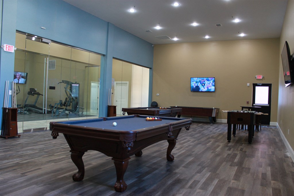 a games room with a pool table and a tv