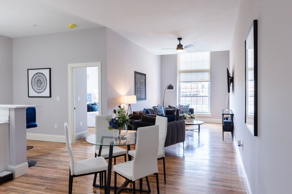 A modern living room with a dining table and chairs.