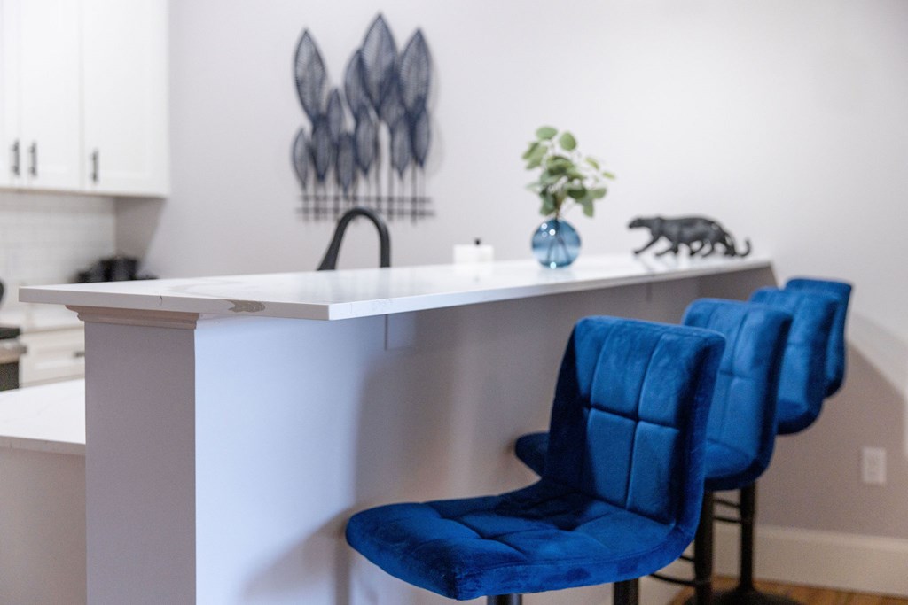 A blue chair sits in front of a white counter.