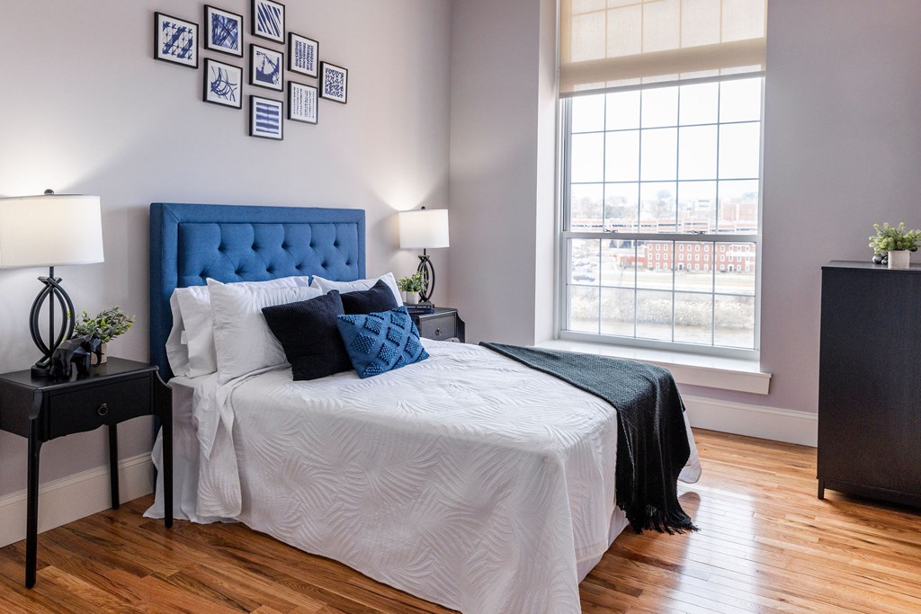 A bedroom with a blue headboard and white bedding.