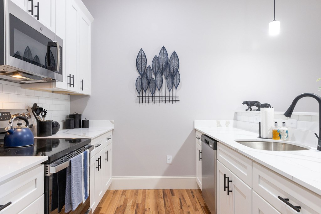 A kitchen with white cabinets and a black stove top.
