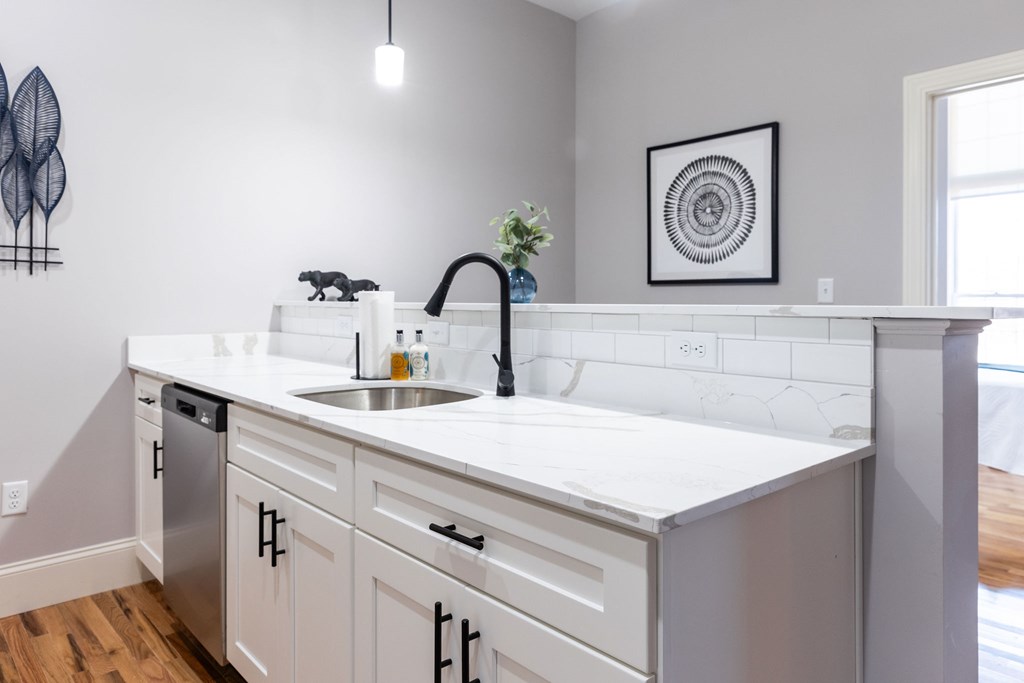 A kitchen with white cabinets and a white counter top.