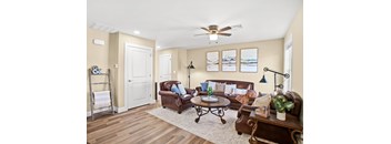 A living room with a brown leather couch and a white door.