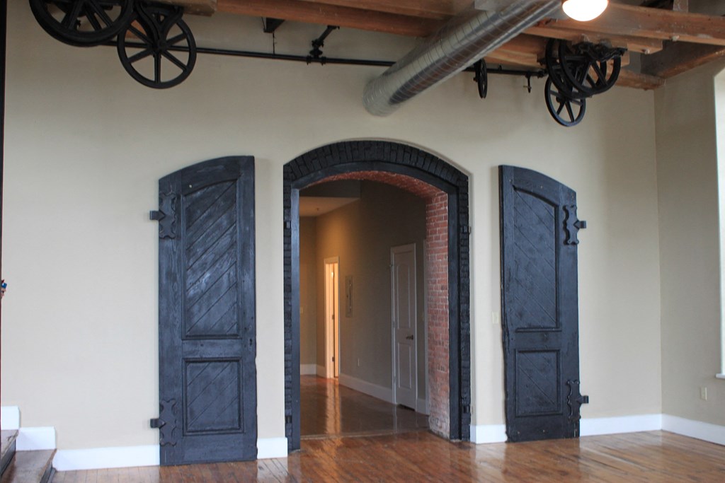 an arched doorway in a room with wooden floors and blue doors